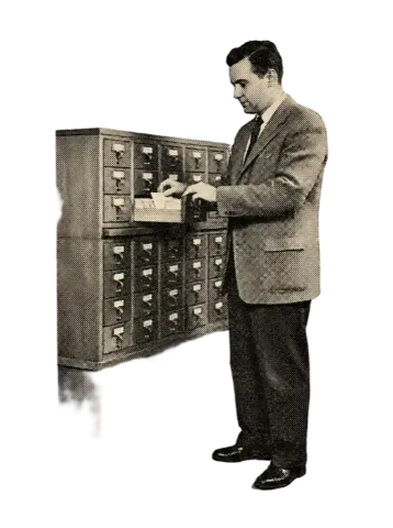A clerk filing cards into a card-index cabinet